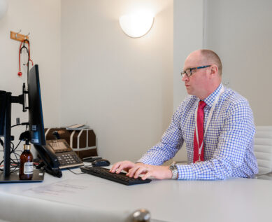 A consultant takes notes on a computer