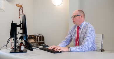 A consultant takes notes on a computer