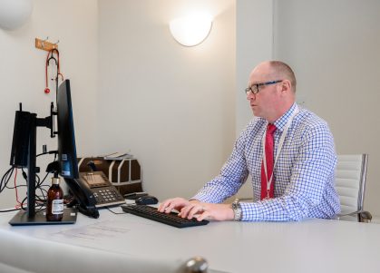 A consultant takes notes on a computer