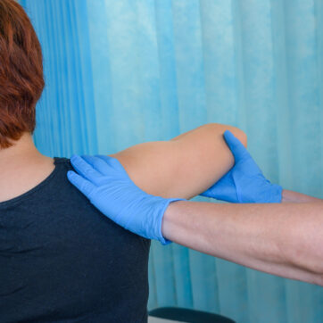 A nurse examines a patient's shoulder